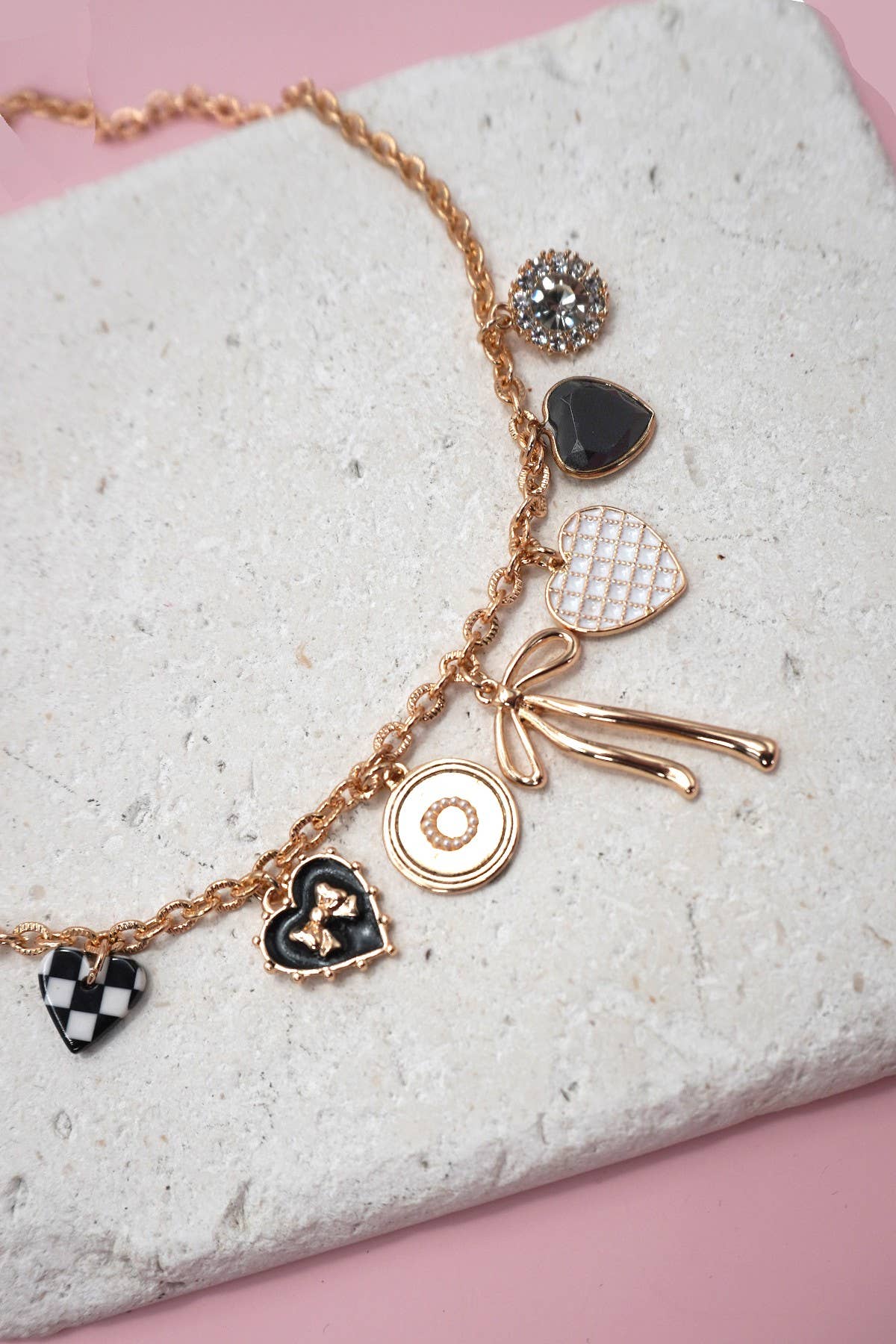 gold necklace with black and white heart charms and gold bow charms