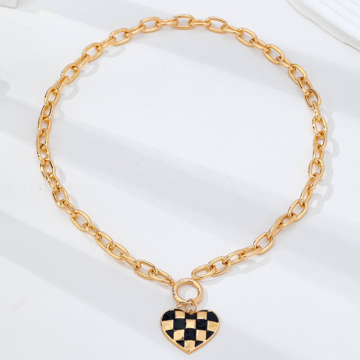 Gold toggle necklace with black and gold checkered heart