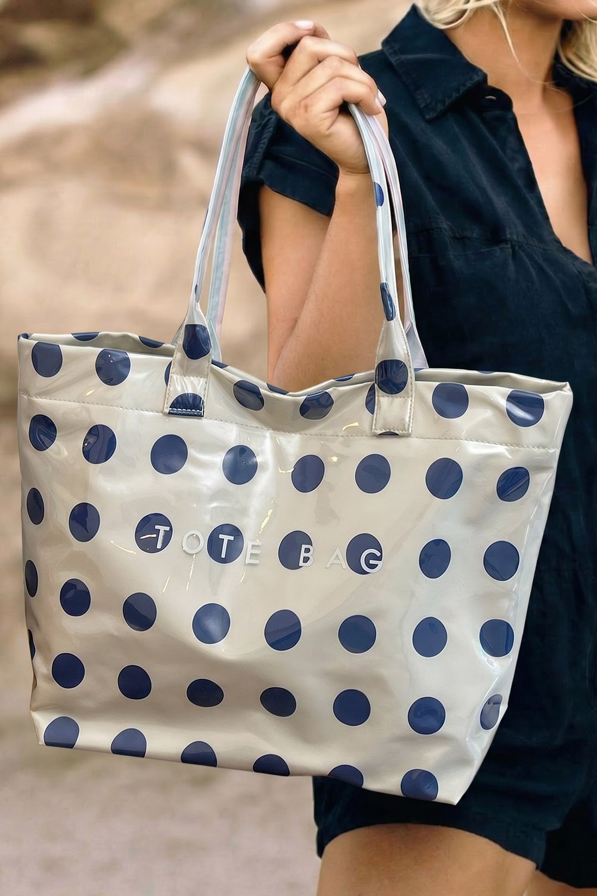 Glossy Waterproof gray tote bag with blue polka dots with the word "tote bag" across the front
