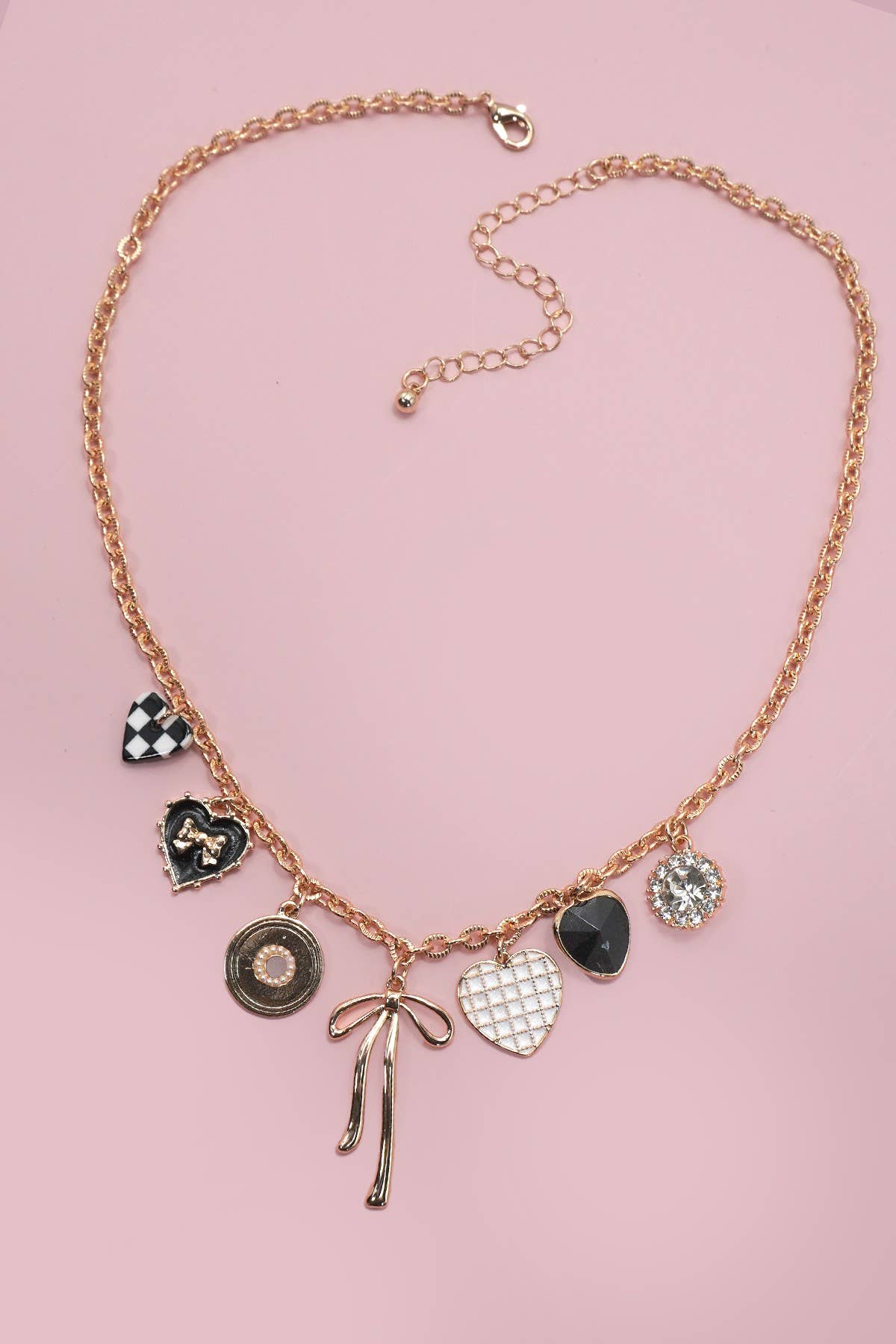 gold necklace with black and white heart charms and gold bow charms.