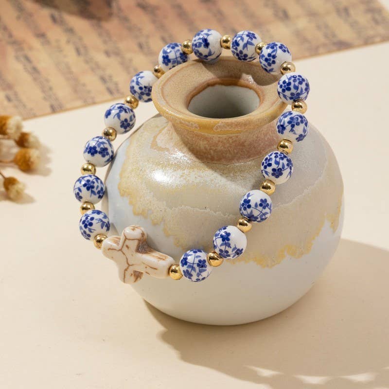 blue and white toile patterned beaded bracelet with a creamy gold cross