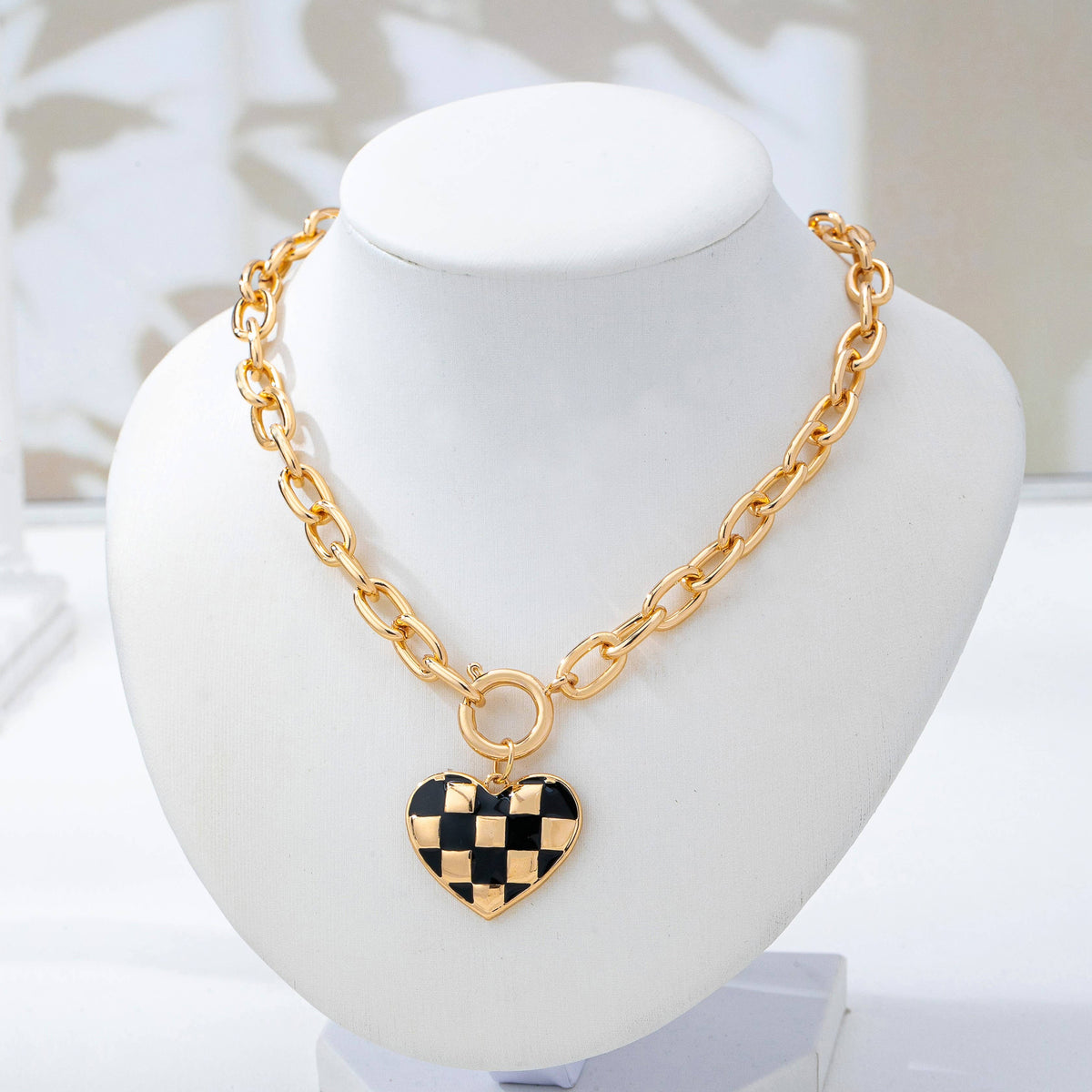Gold toggle necklace with black and gold checkered heart