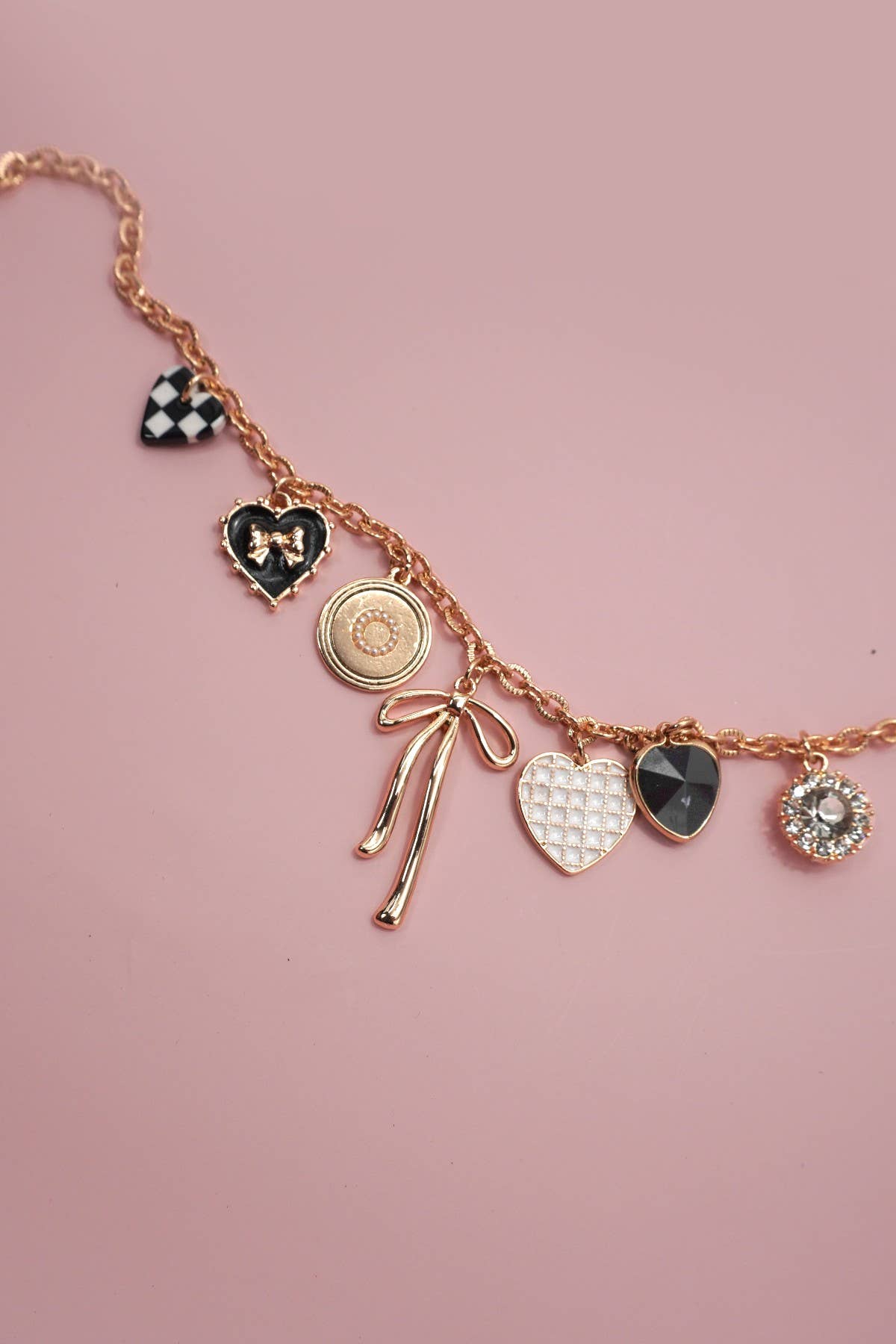 gold necklace with black and white heart charms and gold bow charms