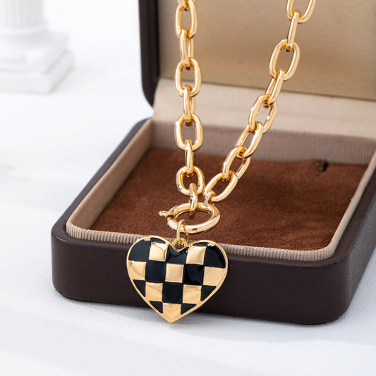Gold chain necklace with a checkered heart pendant 