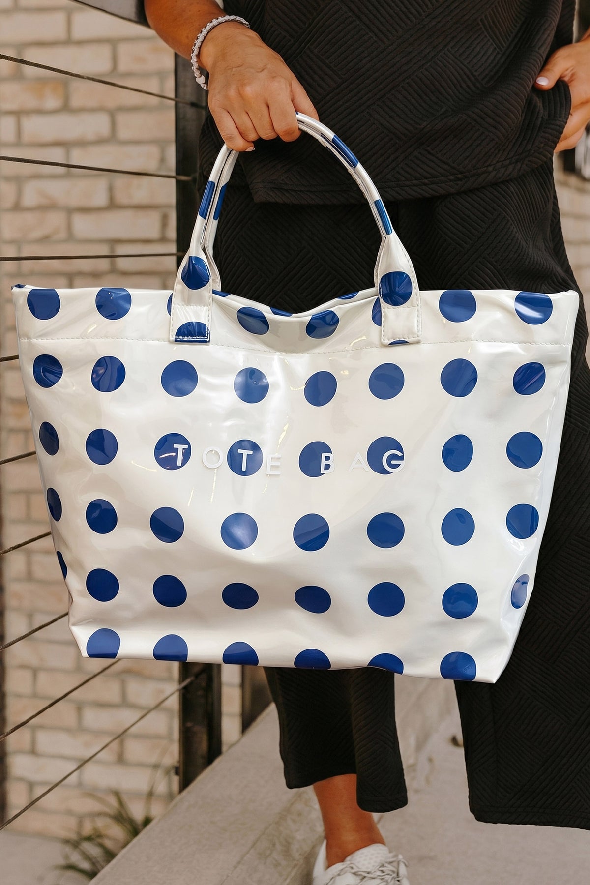 Glossy Waterproof gray tote bag with blue polka dots with the word "tote bag" across the front