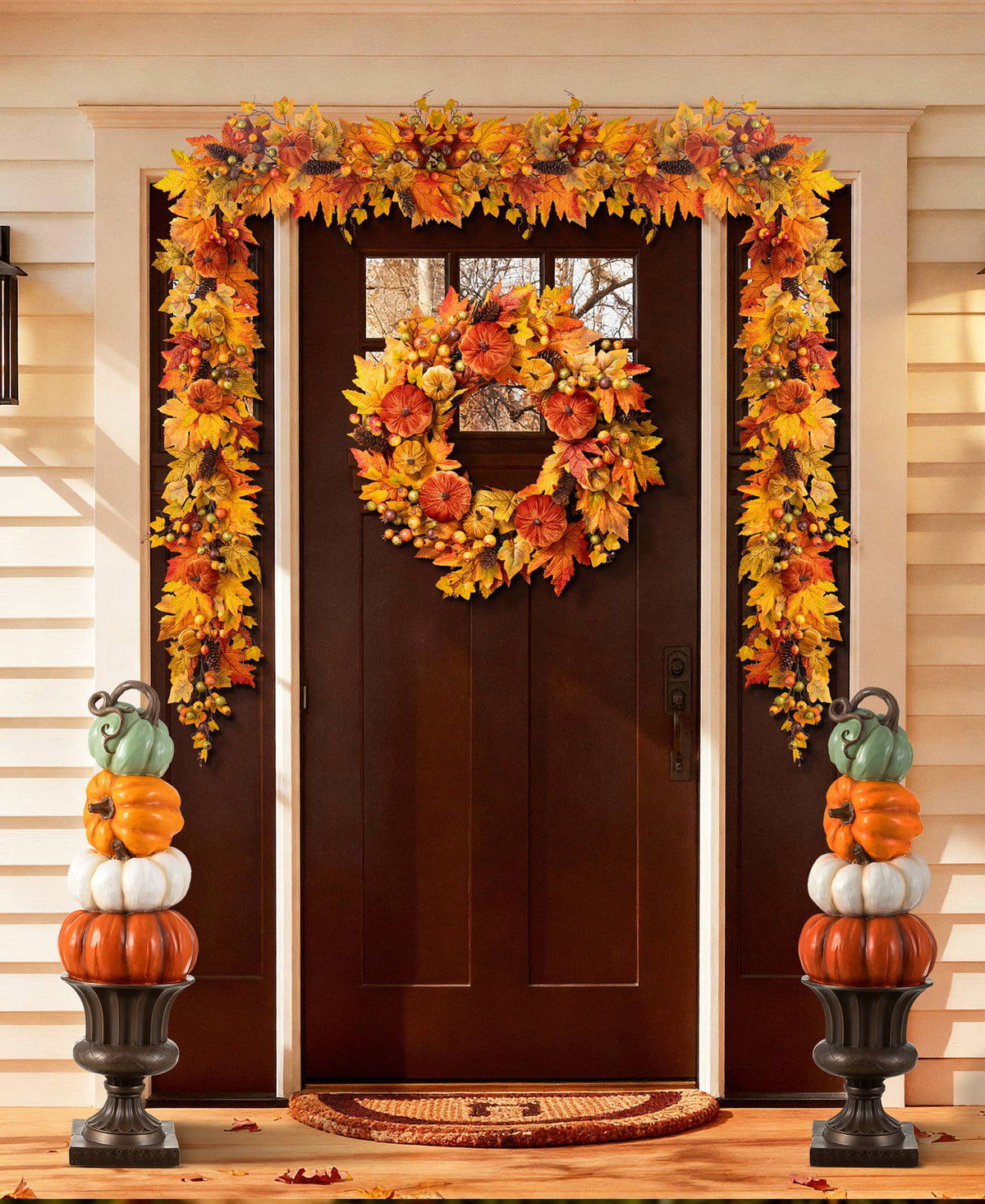 Stack of orange, white, and turquoise pumpkins on an urn for front porch