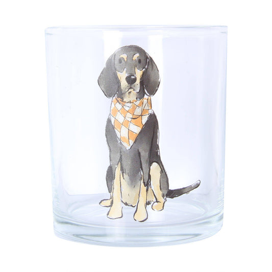 A clear glass tumbler featuring a printed illustration of a black and tan dog wearing an orange and white checkered bandana, set against a plain white background.